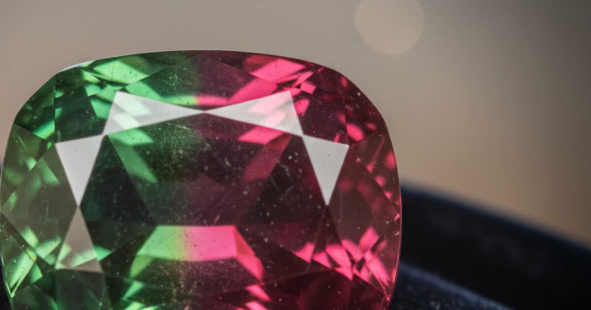 Alexandrite gemstone showing color change from green in daylight to red under incandescent light
