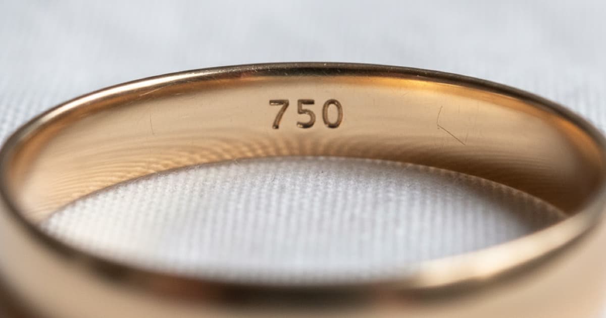 Macro close-up of a 750 hallmark stamp inside a gold ring band