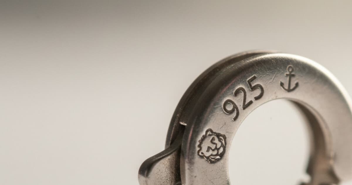 Close-up macro photo of a 925 sterling silver stamp engraved into a jewelry clasp